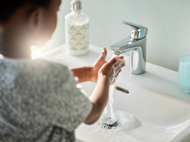 Closeup shot of an unrecognisable boy washing his hands at a tap in a bathroom at home Handwashing is good, because germs are bad! household fixture photos stock pictures, royalty-free photos & images