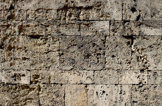 istock Damaged granite stone surface from a wall of a fortress with big bricks, textured with moisture - dirty pattern with for a medieval background 1338854422