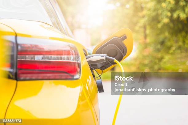 Recharging Electric Car Stock Photo - Download Image Now - Electric Car, Electric Vehicle, Yellow