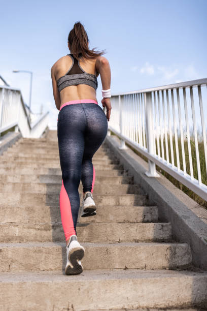 istock Athletic woman running up the stairs 1338854859