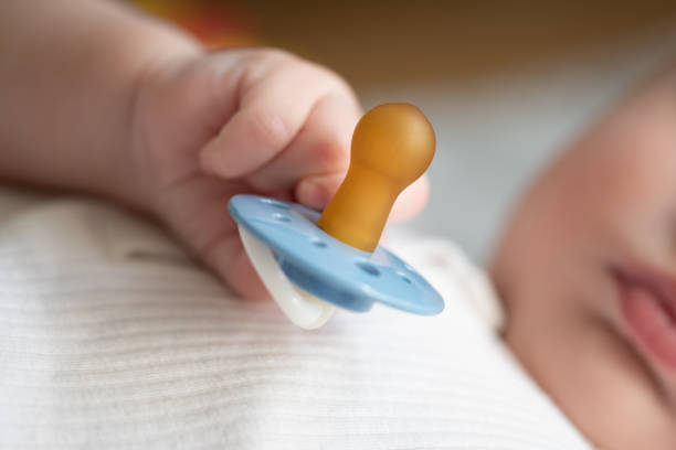 istock hand of baby holding pacifier 1338855656