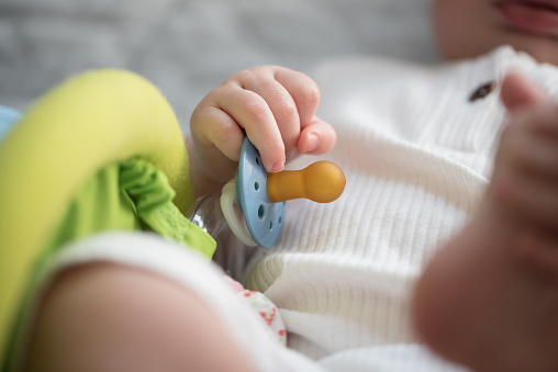 close-up view of hand of baby holding pacifier