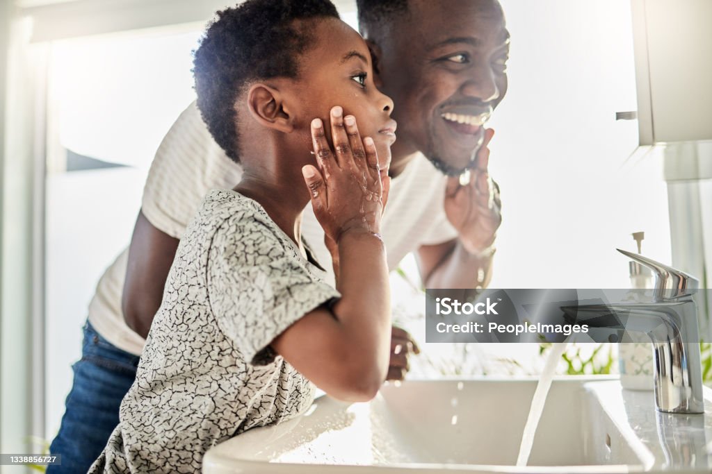 Shot of a father and his son washing their faces together in a bathroom at home Clean skin is happy skin Father Stock Photo