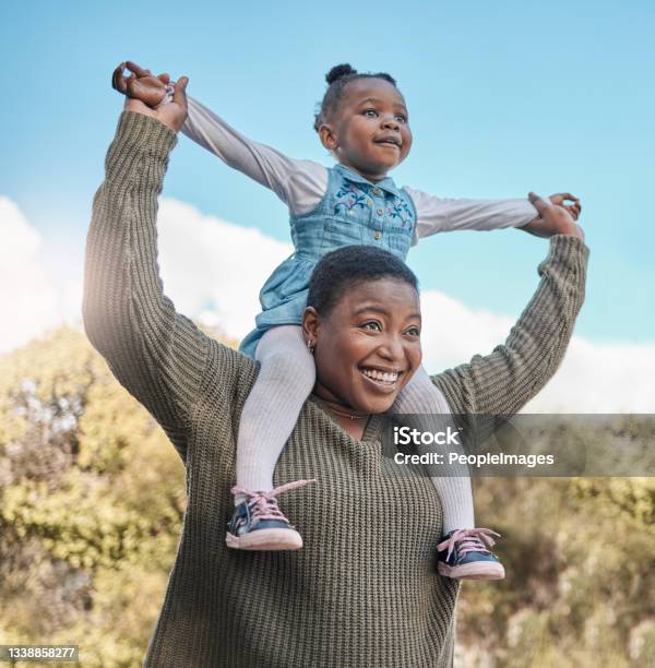 Shot Of A Mother Carrying Her Daughter On Her Shoulders Outdoors Stock Photo - Download Image Now