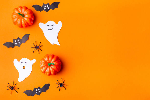 istock Halloween background with spiders, ghosts, bats and pumpkin on orange paper 1338858333