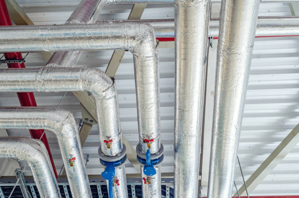 istock Metal pipes mounted under the ceiling are covered with thermal insulation at a modern production plant 1338858879