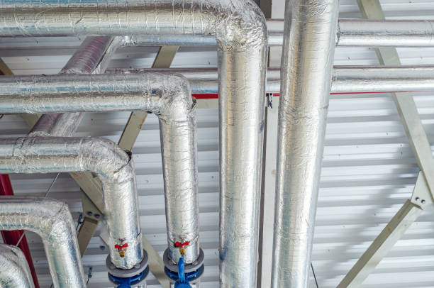 istock Metal pipes mounted under the ceiling are covered with thermal insulation at a modern production plant 1338858884