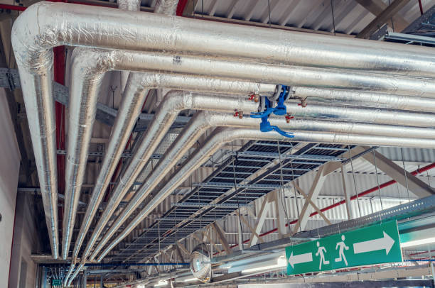 istock Metal pipes mounted under the ceiling are covered with thermal insulation at a modern production plant 1338858885
