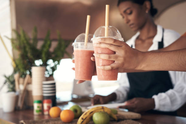 Shot of a businesswoman giving a customer their smoothies Fuel your body in the best way smoothie stock pictures, royalty-free photos & images