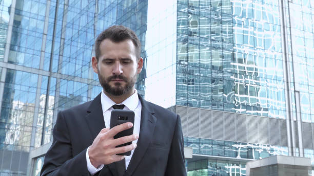 businessman using smartphone while walking - 16936 imagens e fotografias de stock