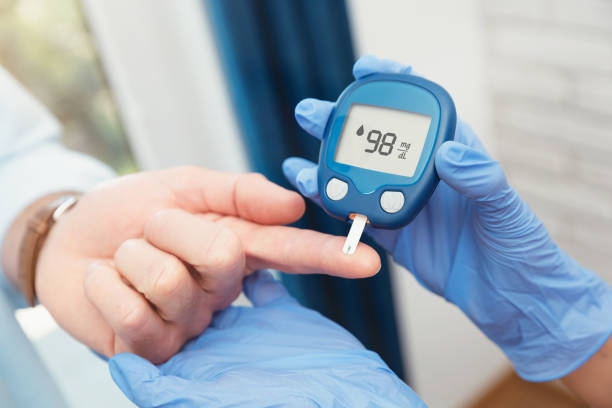Doctor making blood sugar level test in clinic stock photo
