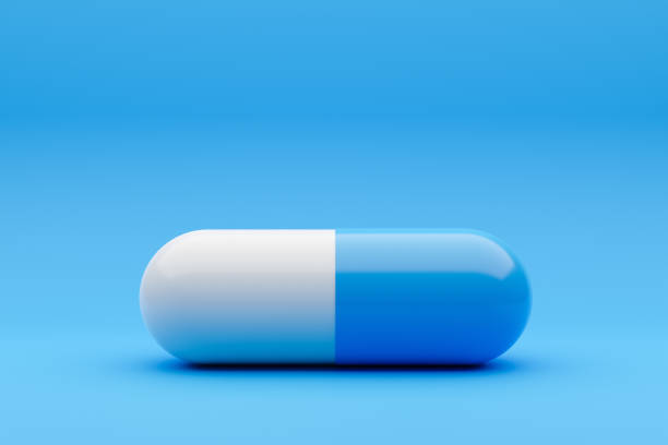Pill capsule on a blue background. stock photo