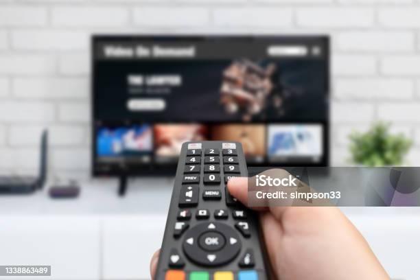 Man Watching Tv Remote Control In Hand Stock Photo - Download Image Now - Television Set, Television Industry, Streaming Service