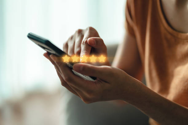 primer plano de la mujer cliente dando una calificación de cinco estrellas en el teléfono inteligente. revisión, calificación del servicio, satisfacción, experiencia de servicio al cliente y concepto de encuesta de satisfacción. - orientado al cliente fotografías e imágenes de stock