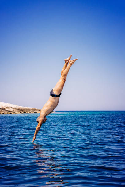 istock Man jumping in sea from sailboat 1338866617