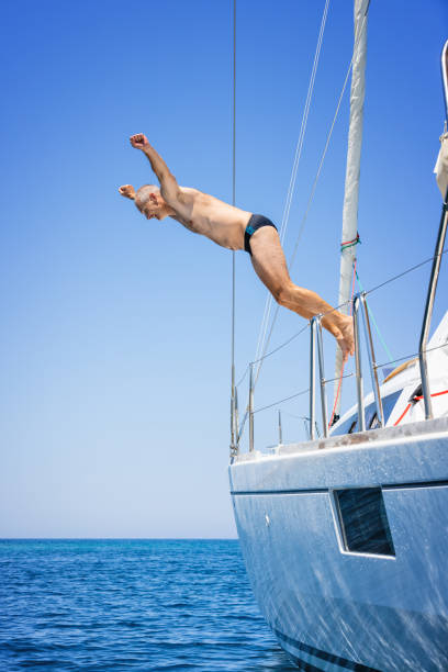 istock Man jumping in sea from sailboat 1338866791