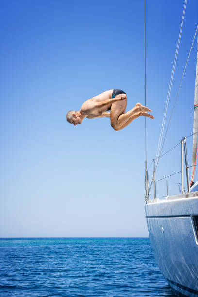 istock Man jumping in sea from sailboat 1338866829
