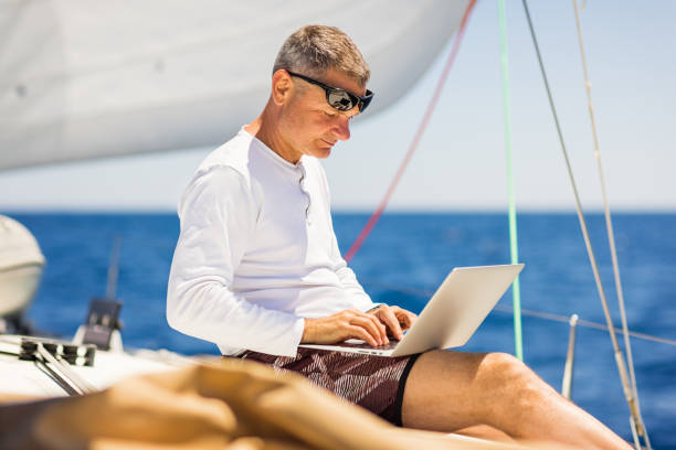istock Businessman with laptop on sailboat 1338867049