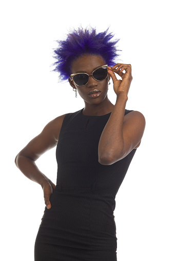 Young beautiful black woman with short purple hair is posing in elegant gold sunglases. Waist up studio portrait isolated on white.