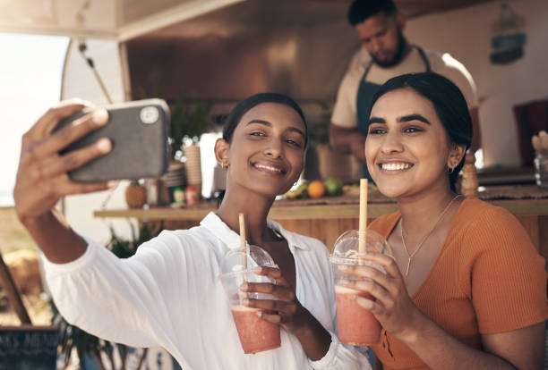 scatto di due amici che scattano selfie mentre bevono frullati - blueberry smoothie milk shake drink foto e immagini stock