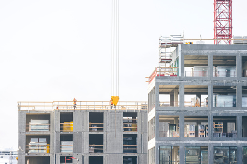 Construction site with cranes at Nordø in Copenhagen, Denmark. Workers in work with concrete. In this upscale neighbourhood you find luxury residential homes, offices and corporate buildings as well as shopping centers along the beautiful chanels.