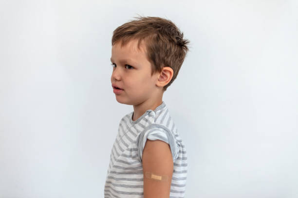 istock Child showing his arm with bandage after getting vaccine. 1338868740