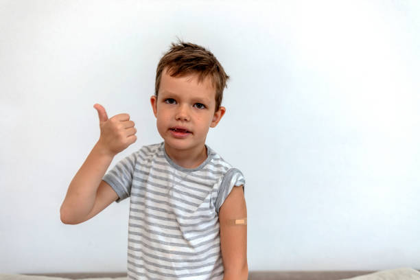istock Vaccinated boy showing arm after vaccination with thumb up. 1338869499