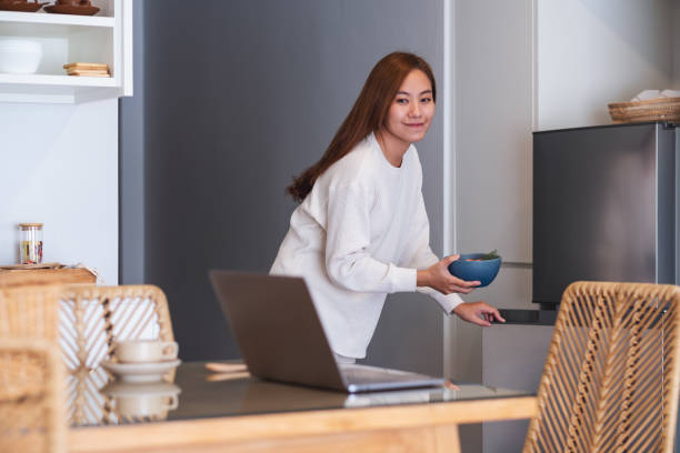 istock A woman going to eat food while taking a break from working or studying online at home 1338872936