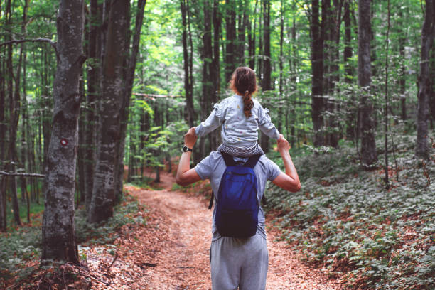 istock Father walks with his daughter in the forest 1338873860