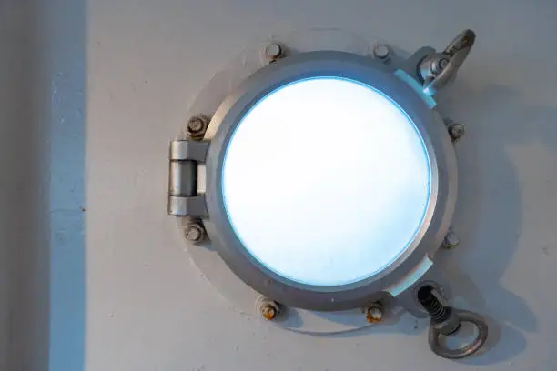 Porthole in the ferry cabin. The ferry sails on the sea.