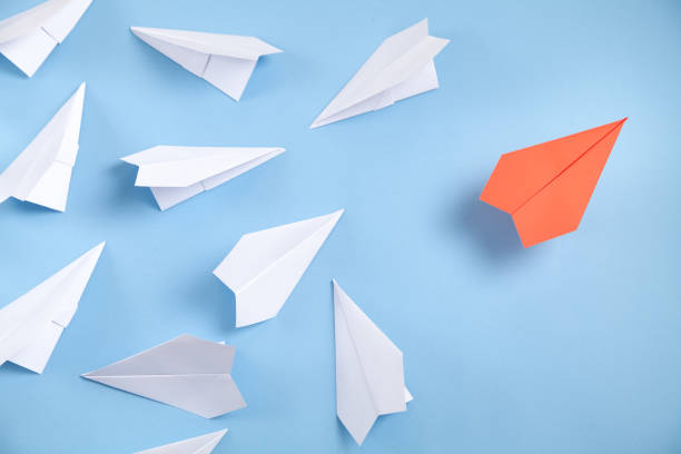 istock Red and white paper airplanes on blue background. Leadership. Teamwork 1338875998