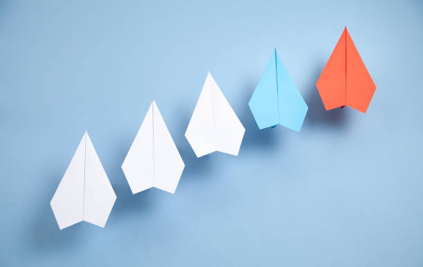istock Red and white paper airplanes on blue background. Leadership. Teamwork 1338875999