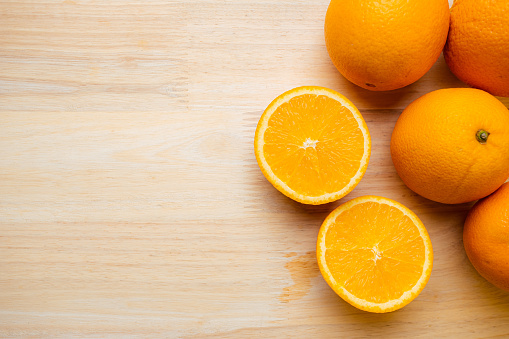 Orange fruit raw material for make juice. Orange on wooden table.
