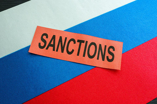 Russian flag and word sanctions as symbol of economical restrictions.