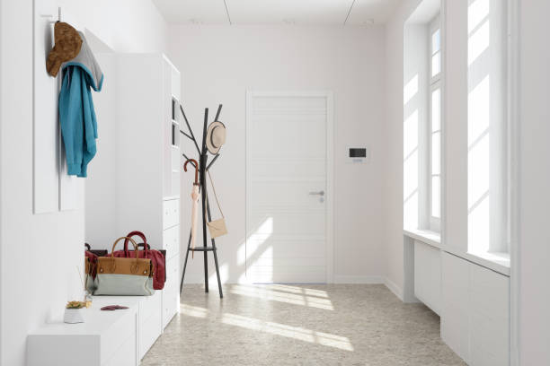 front door entrance to house with white cabinets and coat hanger in corridor. - ingang stockfoto's en -beelden