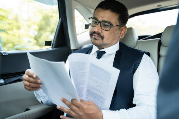 istock young businessman reading project documents while traveling in car - Concept of successful happy people 1338880726