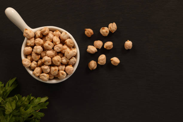 Chick Peas from Legume Family Chick Peas from Legume Family on black slate background. High resolution 45Mp image using Canon EOS R5 with associate macro lens chickpea stock pictures, royalty-free photos & images