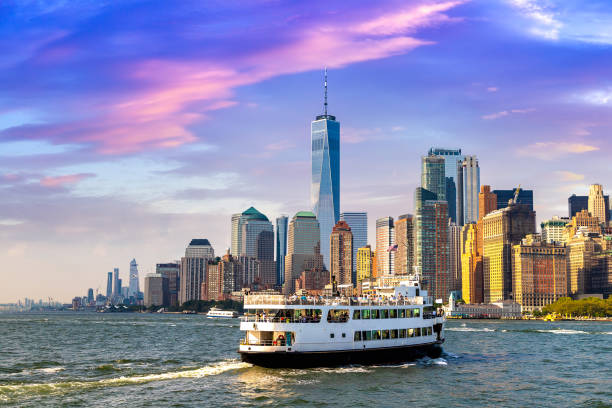Manhattan cityscape in New York Panoramic view of Manhattan cityscape and ship ferry in New York City at sunset, NY, USA ferry stock pictures, royalty-free photos & images