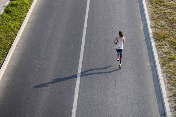 istock Young woman jogging on the road 1338884105