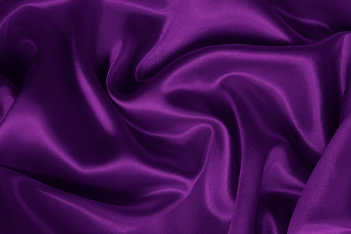Dark purple fabric cloth texture for background and design art work, beautiful crumpled pattern of silk or linen.