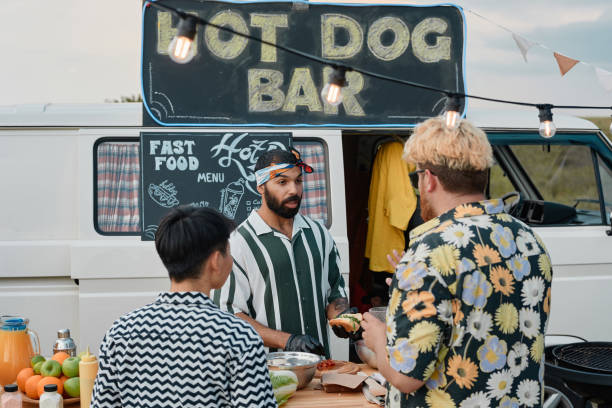 istock Man cooking hot dogs for people 1338884929