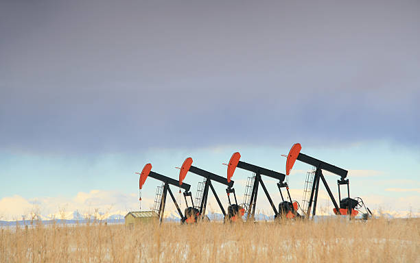 quattro rosso giacimento petrolifero pumpjacks in alberta - oil pump oil industry prairie field foto e immagini stock