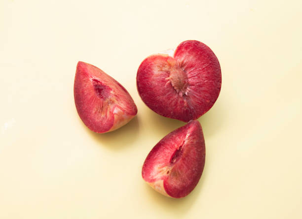 cortado de fruta plumcot con pulpa roja - fruit stone fotografías e imágenes de stock