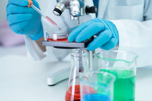 istock Asian scientist biochemist or microbiologist working research with a microscope in laboratory. For protect outbreak Coronavirus Covid19, bacteria and germs. 1338892450