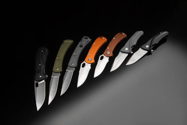 istock Various folding pocket knives on a dark background. A versatile pocket tool and self-defense tool. 1338892581