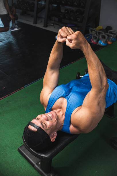 istock A fit man does a lying isometric chest squeeze on a bench while at the gym. Contracting and flexing pectoral muscles. 1338894030