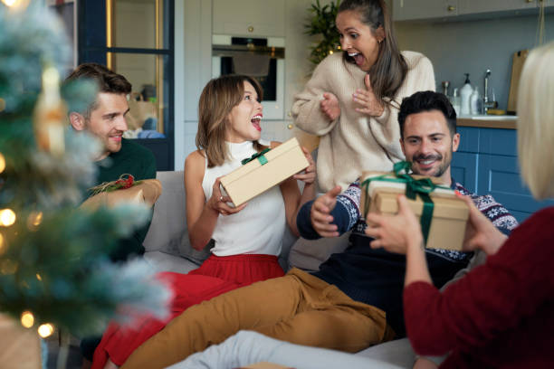 istock Joyful friends unwrapping Christmas presents 1338895646