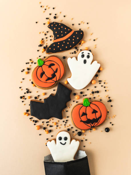 istock Various Halloween gingerbread cookies - Jack O'Lanterns, black hat, ghosts, bat and sugar sprinkles scattering of paper bag 1338895878