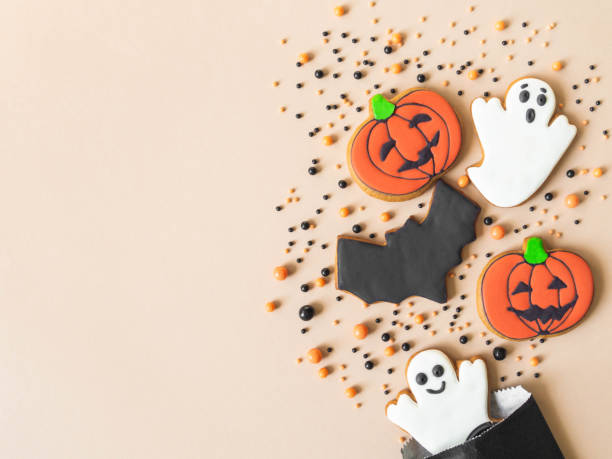 Various Halloween gingerbread cookies - Jack O'Lantern, ghosts, bat and sugar sprinkles scattering of paper bag