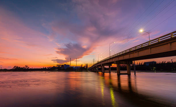 istock Bridge over river in the evening. The light from the lamp to the reflector surface,Container Terminal in Hamburg, Germany. Bridge is called Koehlbrandbruecke - a bridge about the harbor. 1338896018